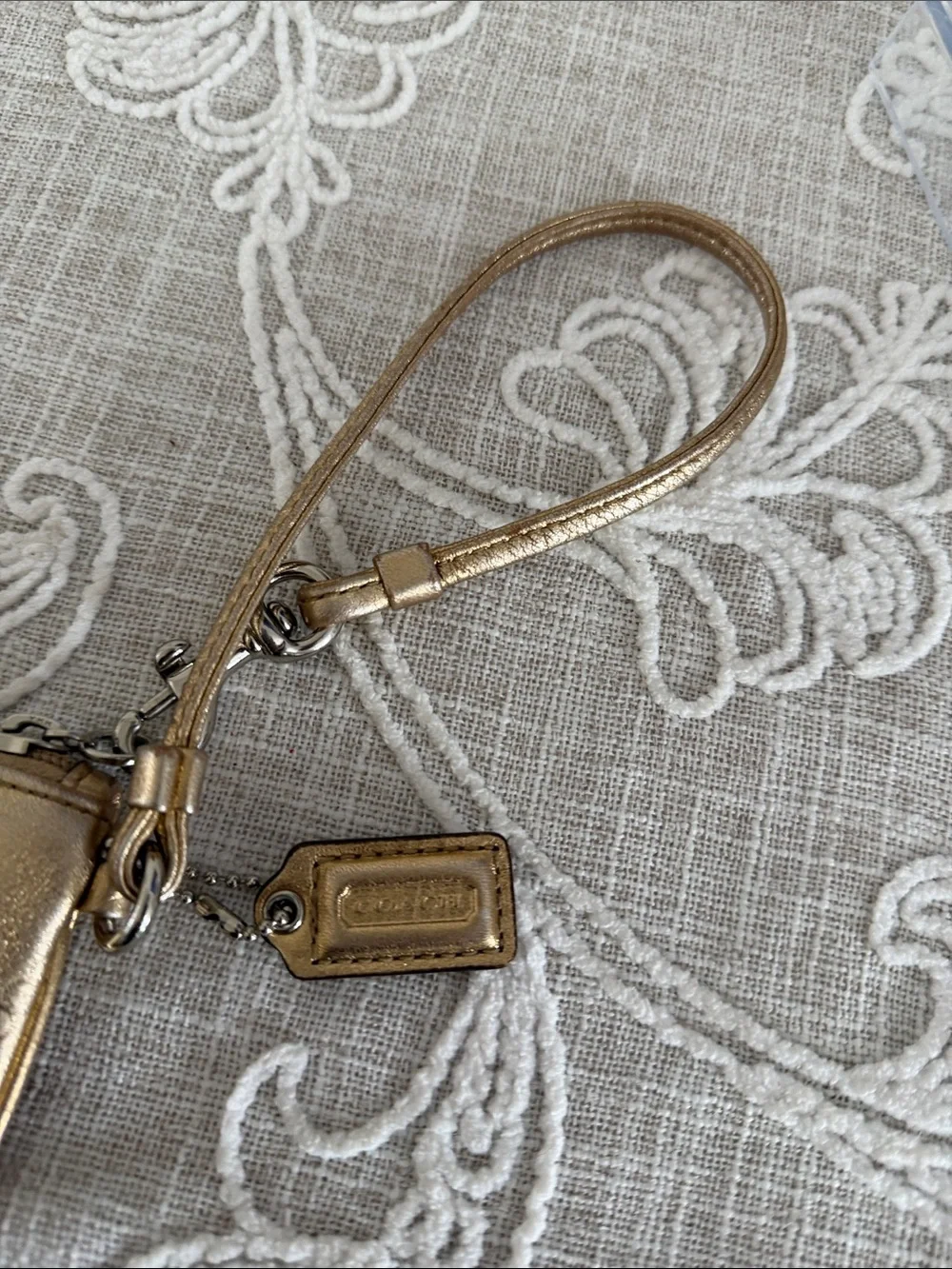 Coach Metallic Gold Wristlet with Embossed Chain Motif